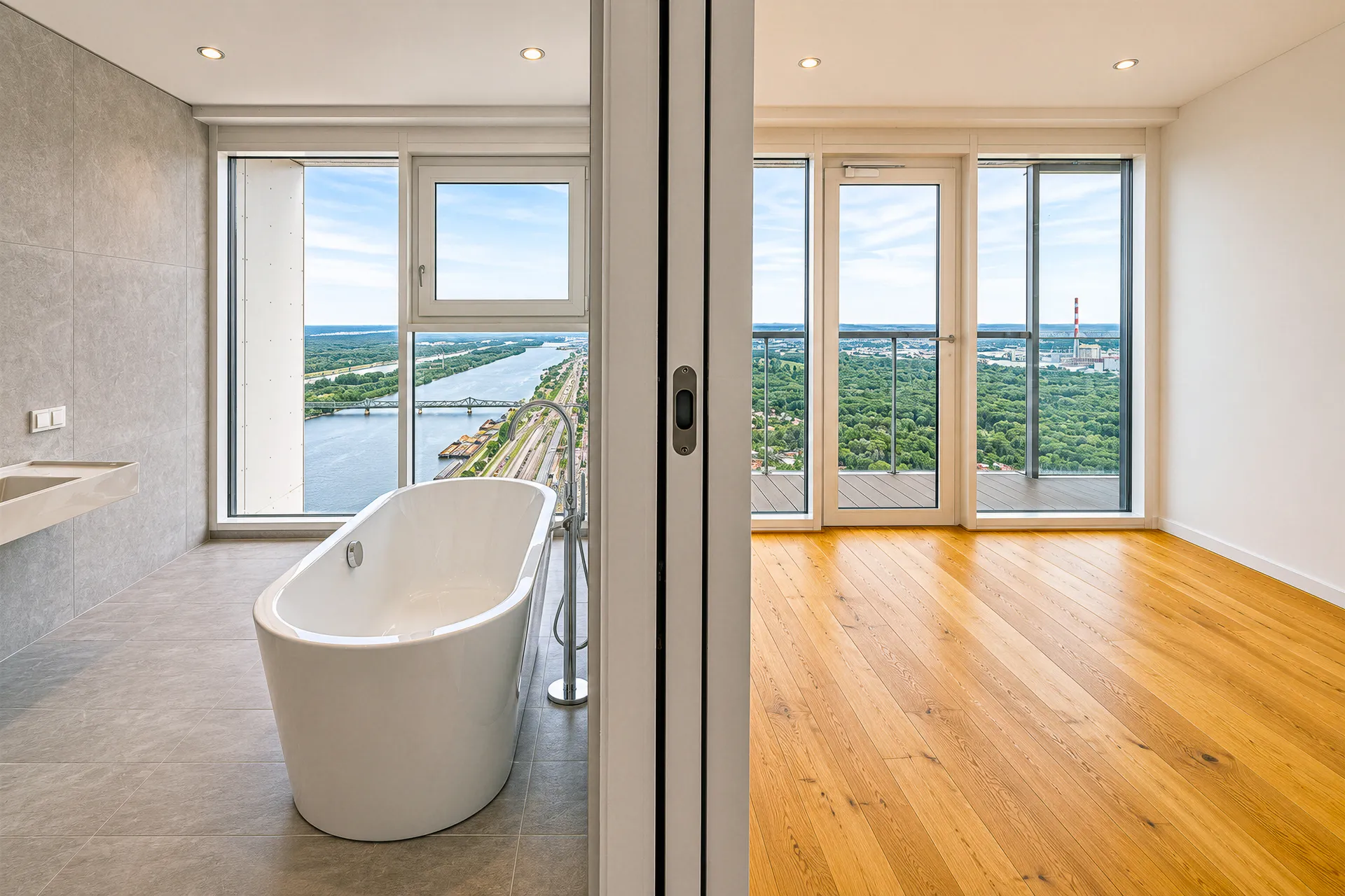 Badezimmer mit freistehender Wanne und Donaublick